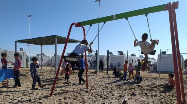 Children playing in a reception centre's playground, on the Greek islands