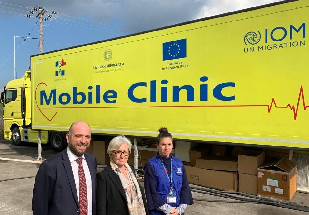 3 adults standing in front of a mobile health truck