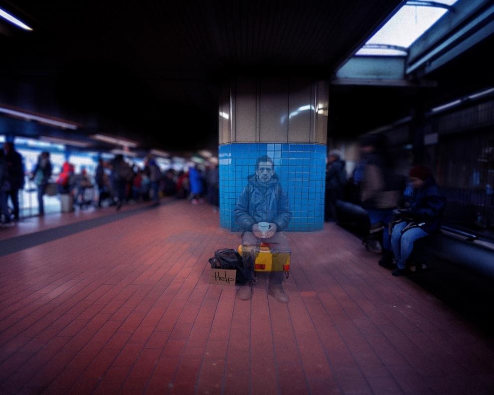 In a dark train station, surrounded by busy people, the figure of a man who is begging appears. He is almost transparent, suggesting the invisibility of victims of trafficking in human beings. 
