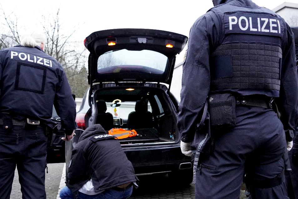 The photo shows German police staff searching a car, suggesting that the driver is under investigation.