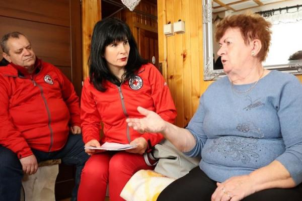 The image displays woman named Julia who accommodated 7 women from Ukraine. There are two employees of Slovak Red Cross (on the left) interviewing Julia.